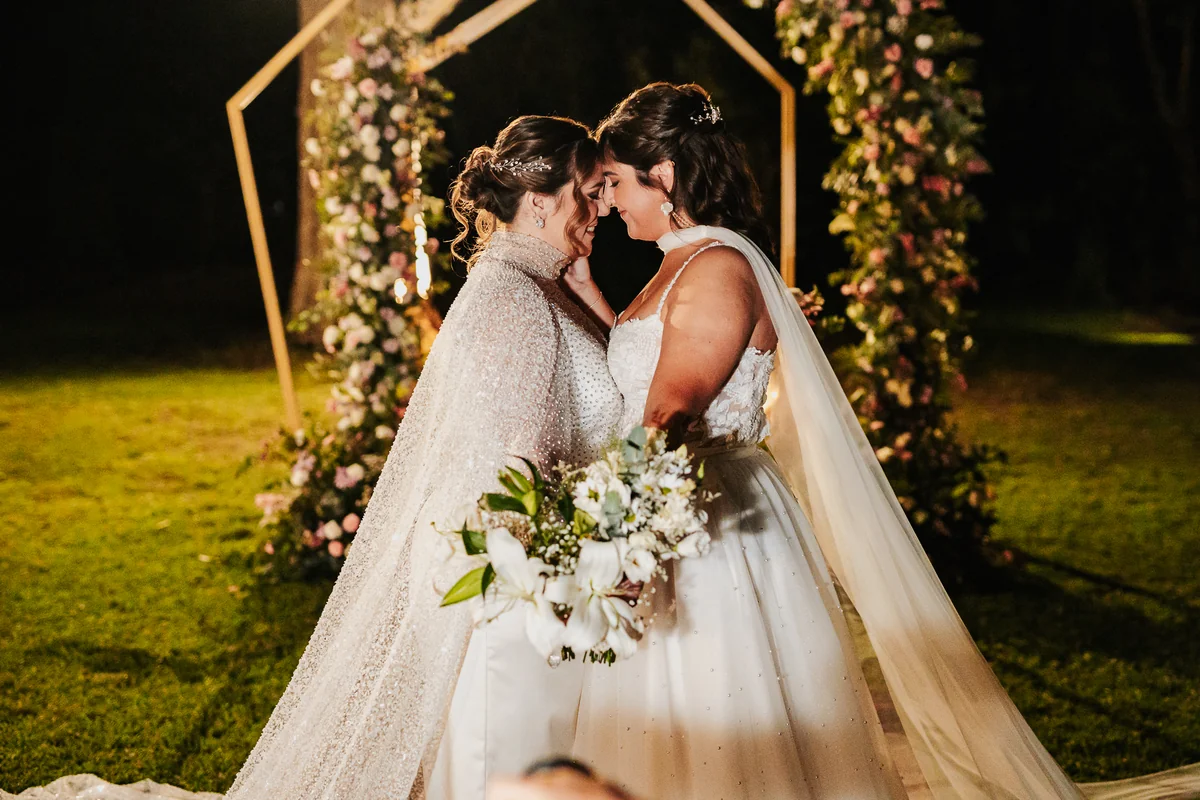 Abrazo de los novios bajo las luces · Kuma Studio